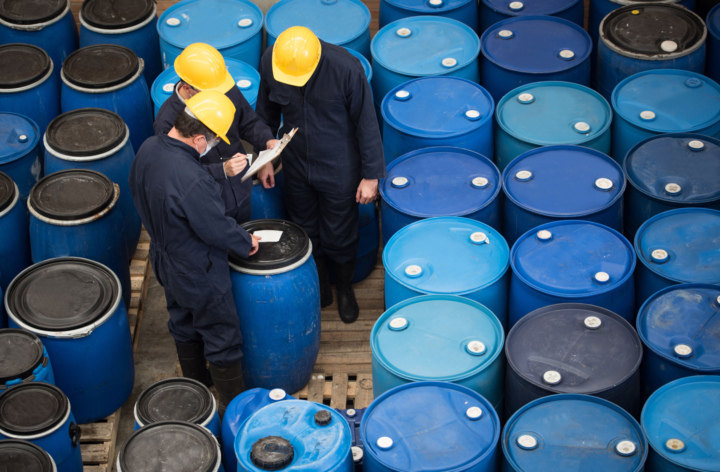 hon-workers-inspecting-chemical-drums-warehouse-518247394.jpg