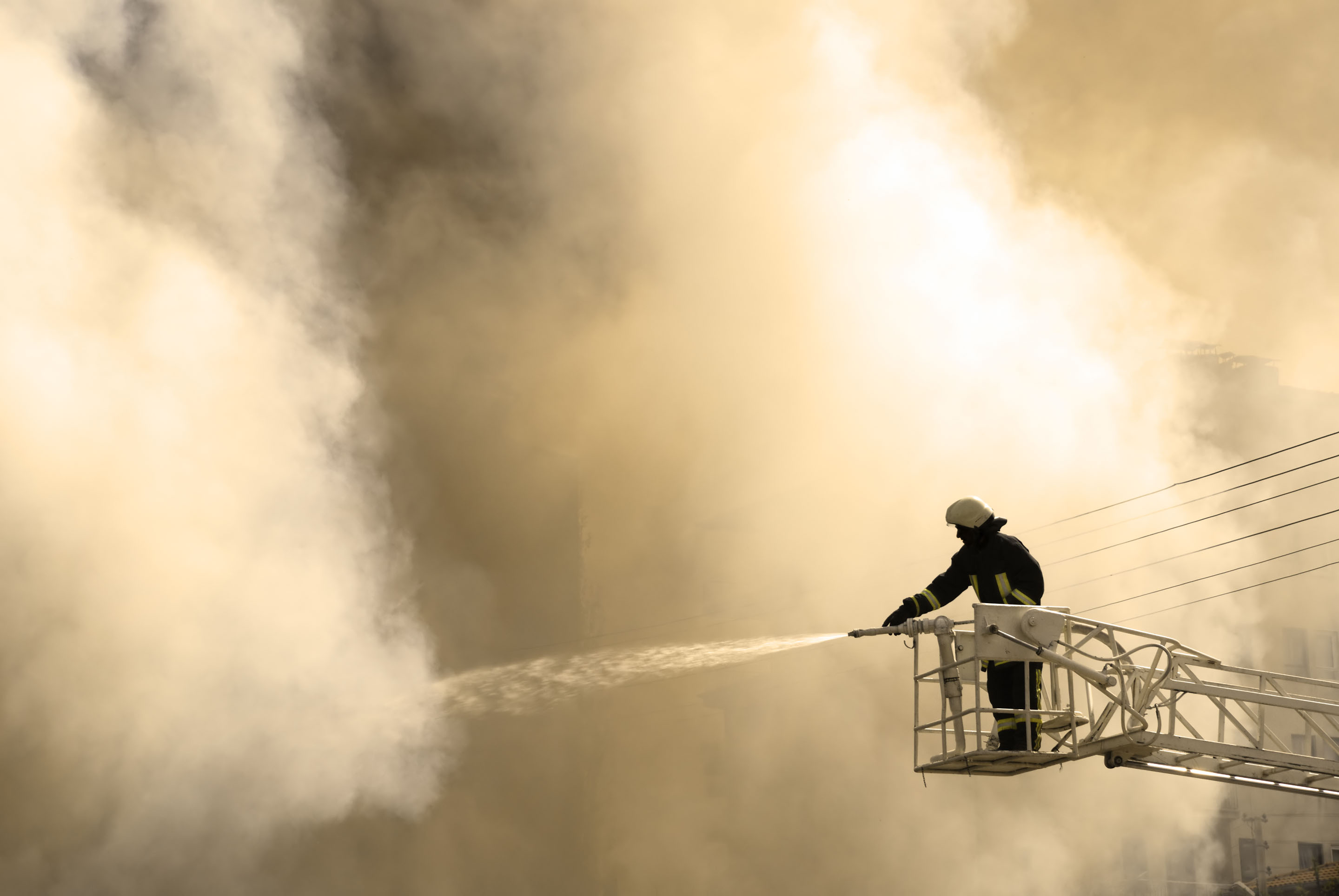 hon-firefighter-aerial-platform-hosing-building-fire-94368090.jpg