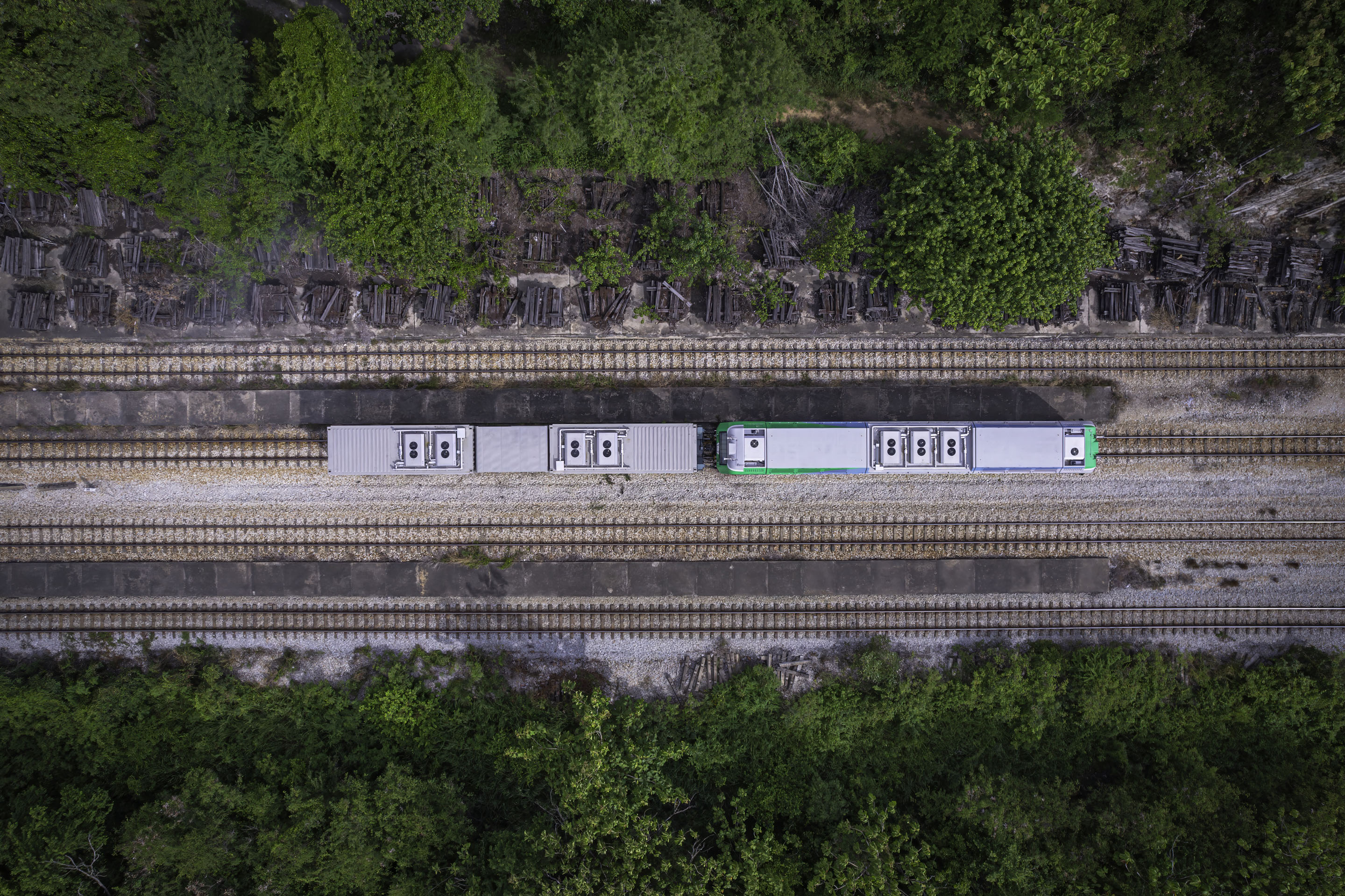 hon-aerial-metro-train-cars-rail-tracks-green-forest-1592011665.jpg